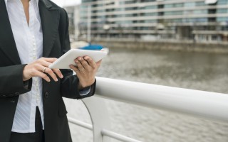 mid-section-young-woman-standing-near-harbor-using-mobile-phone