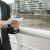 mid-section-young-woman-standing-near-harbor-using-mobile-phone